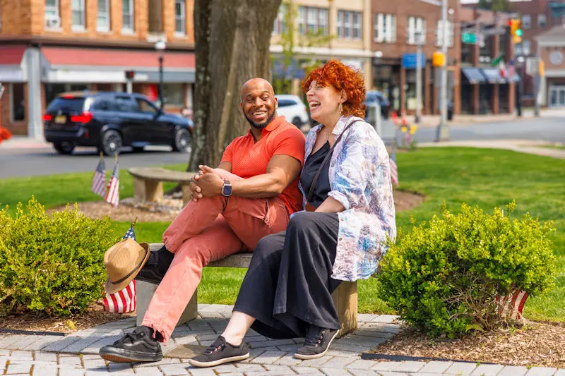 Couple sat on a bench smiling